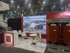 A professional display of an LED screen rental at a trade show booth in Orlando, featuring a detailed image and branding for TMC, with chairs and a table arranged around the setup.